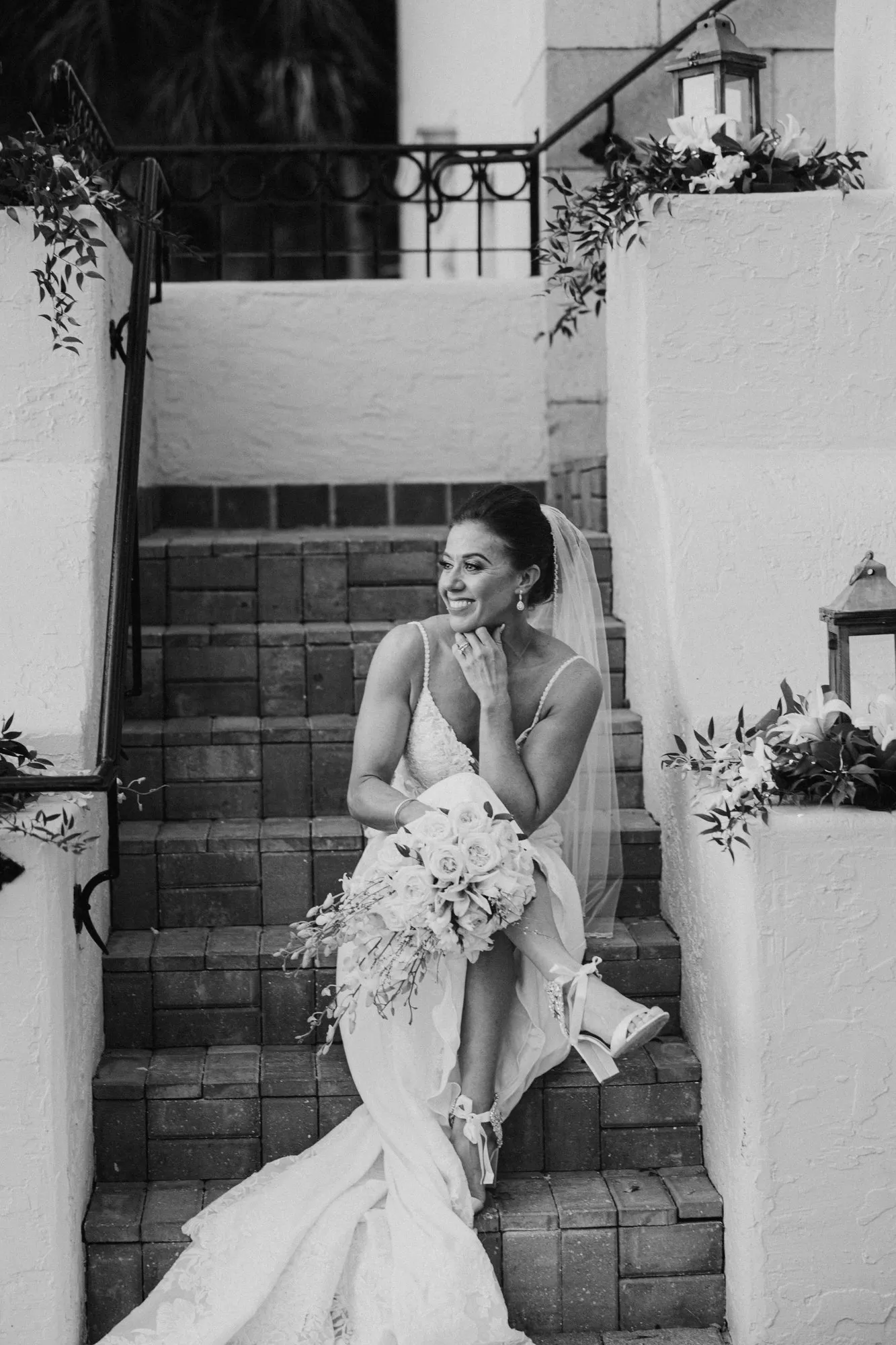 Bride sitting on the mansion's brick steps at Powel Crosley Estate, in black and white