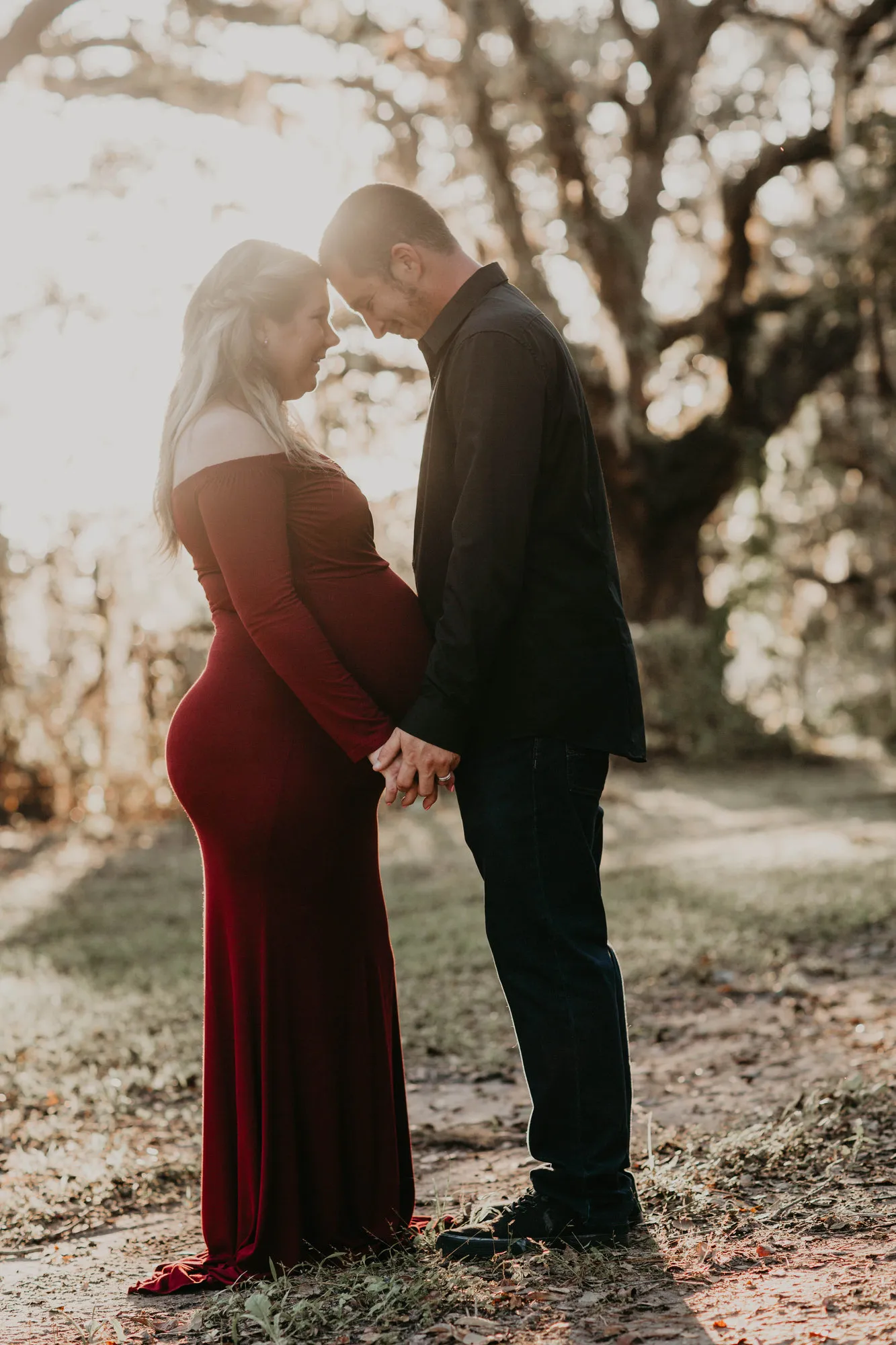 Couple touching foreheads, backlit by the low sun