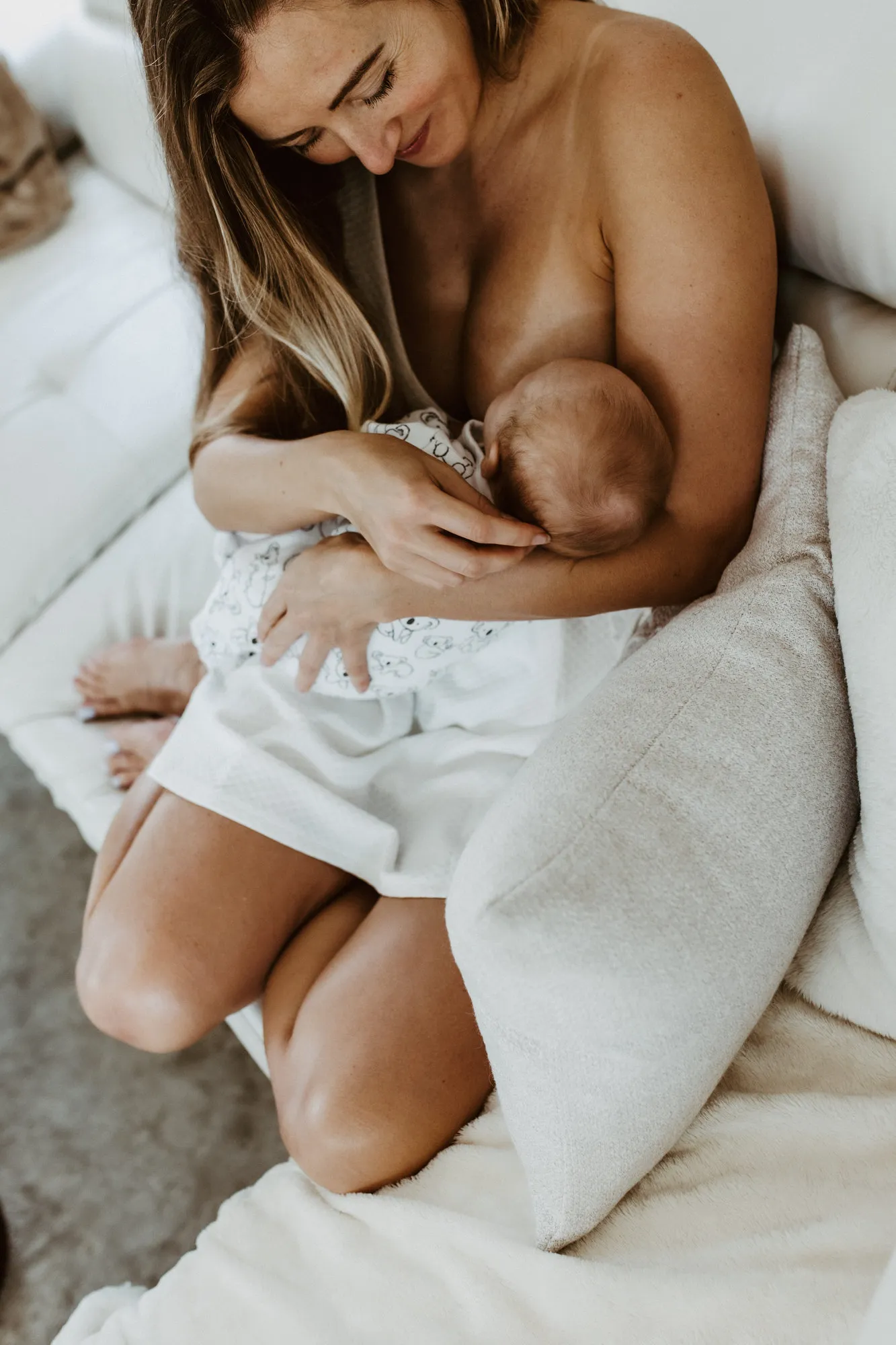Mother looking down at her newborn as he nurses