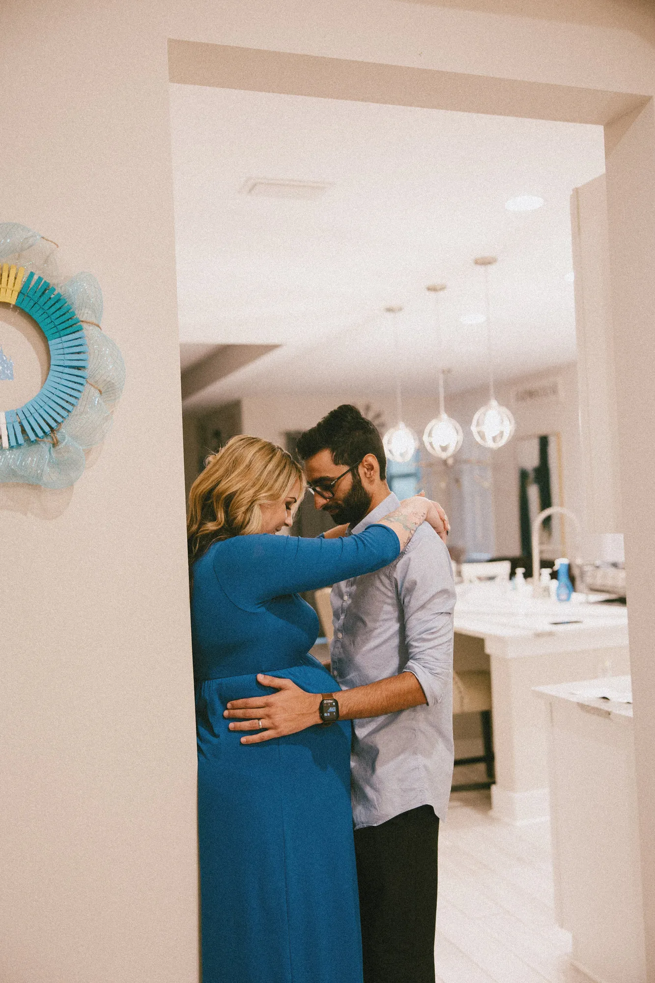 Couple embracing in a doorway at home, foreheads together