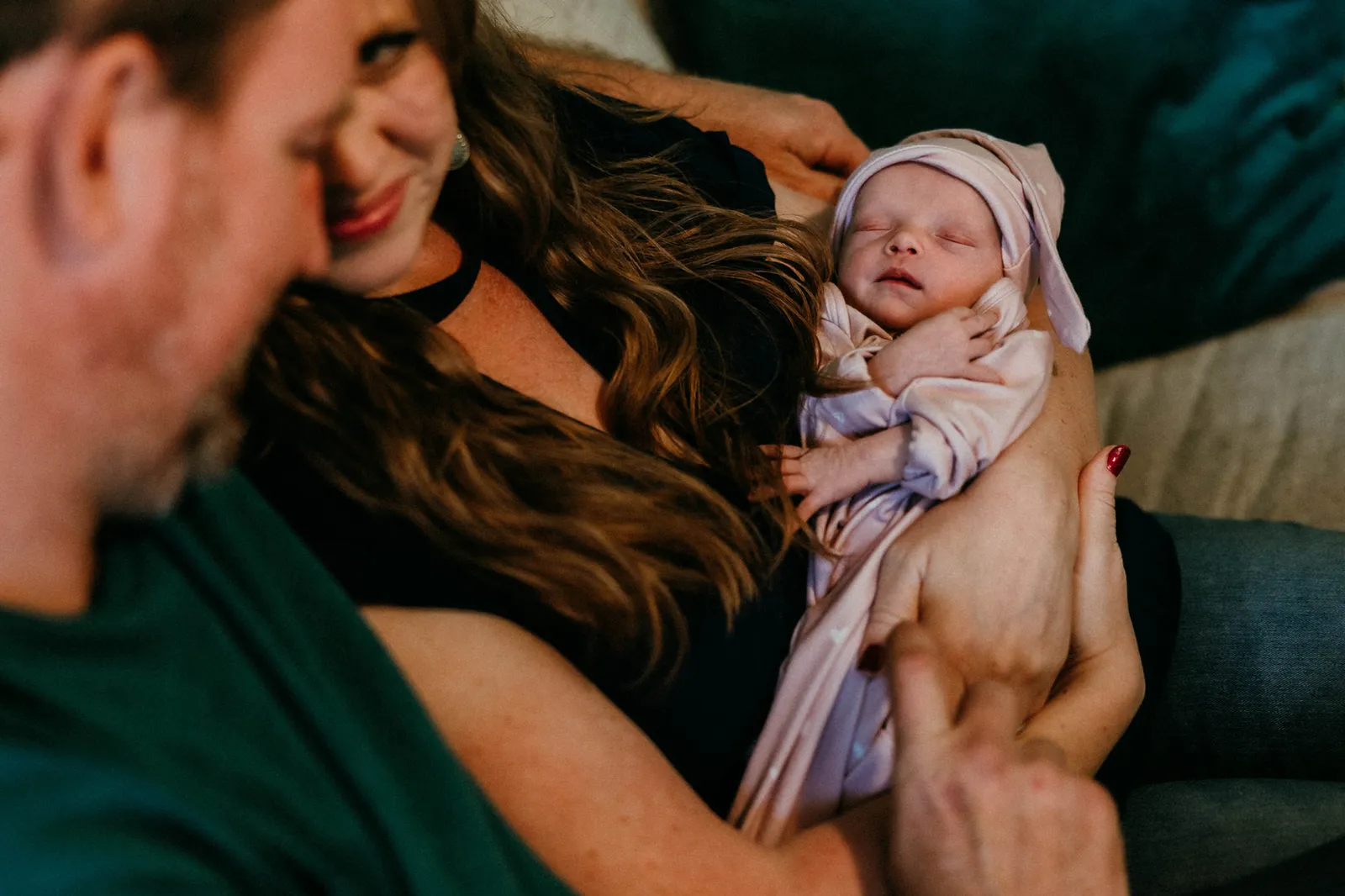 Mother holding her newborn as the father leans in