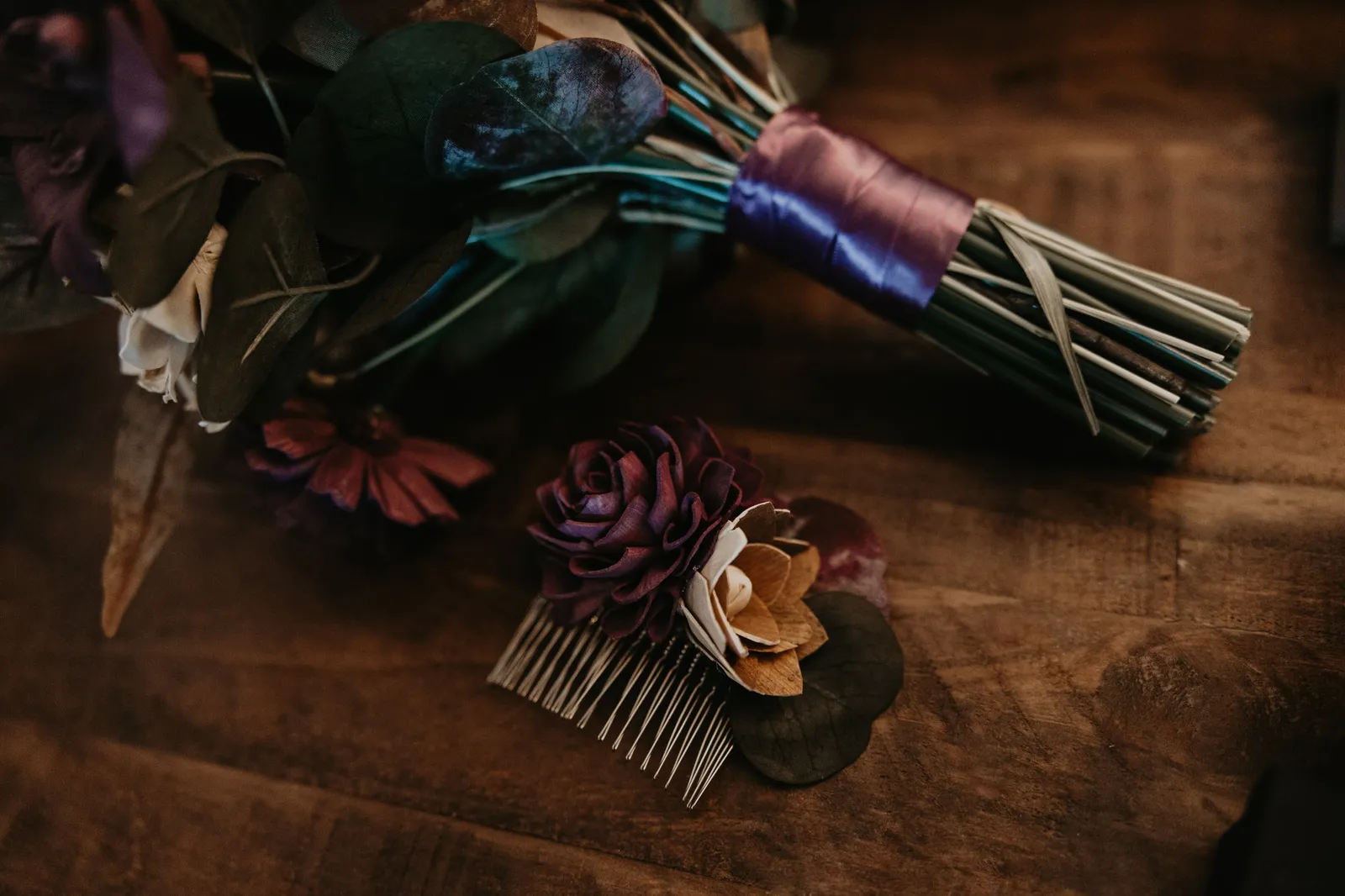 Bouquet tied with purple ribbon beside a wooden flower hair comb