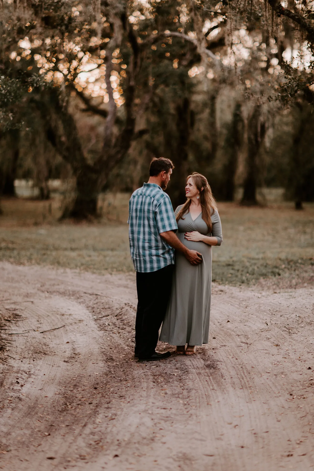 Couple facing each other on a dirt track at dusk