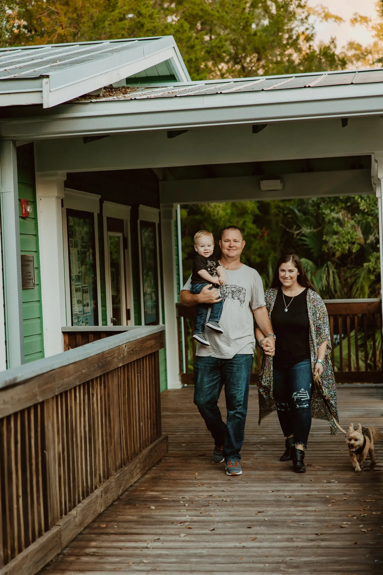 Family walking along a boardwalk with their dog