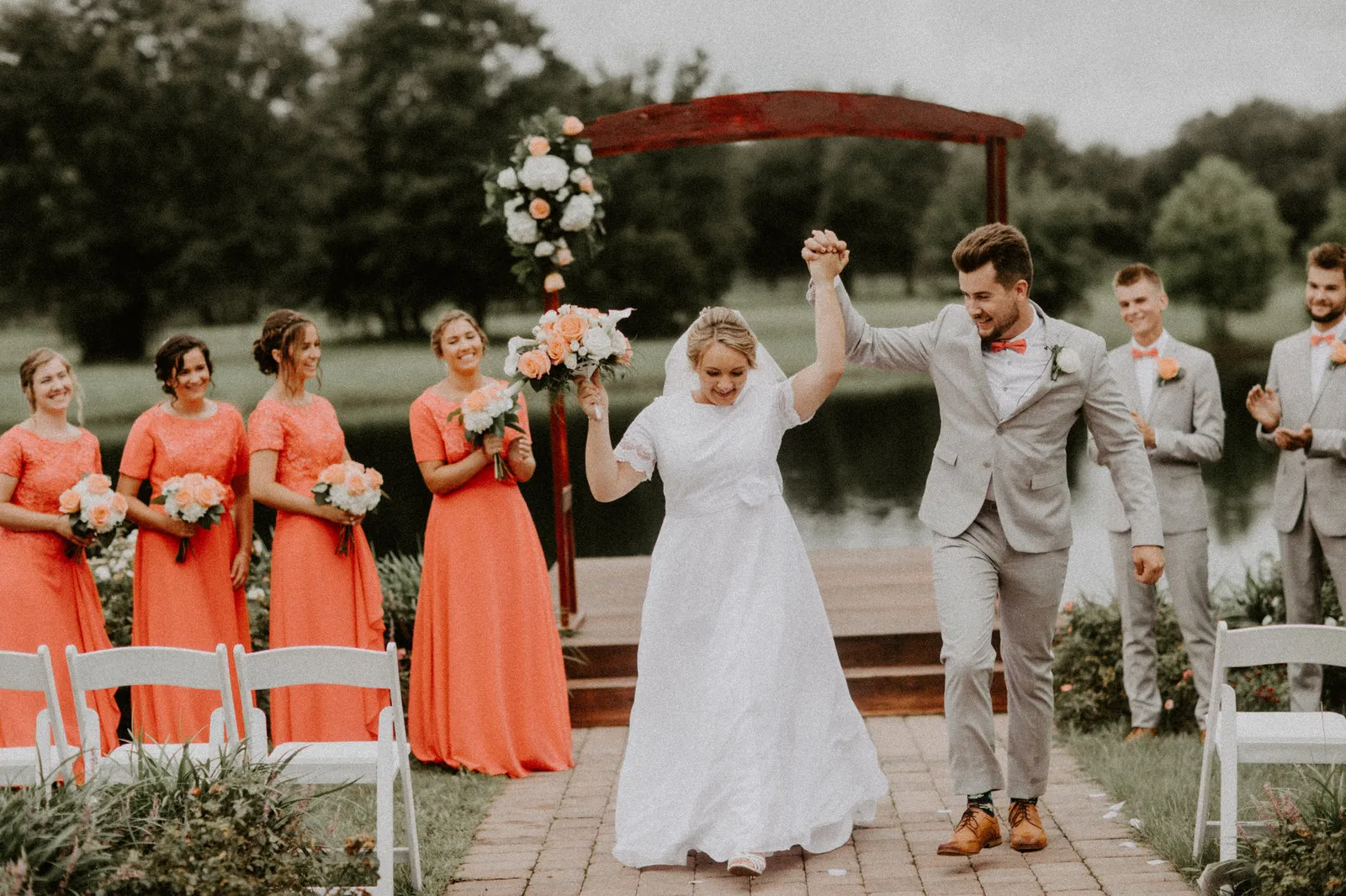 Bride and groom cheering as they walk back up the aisle