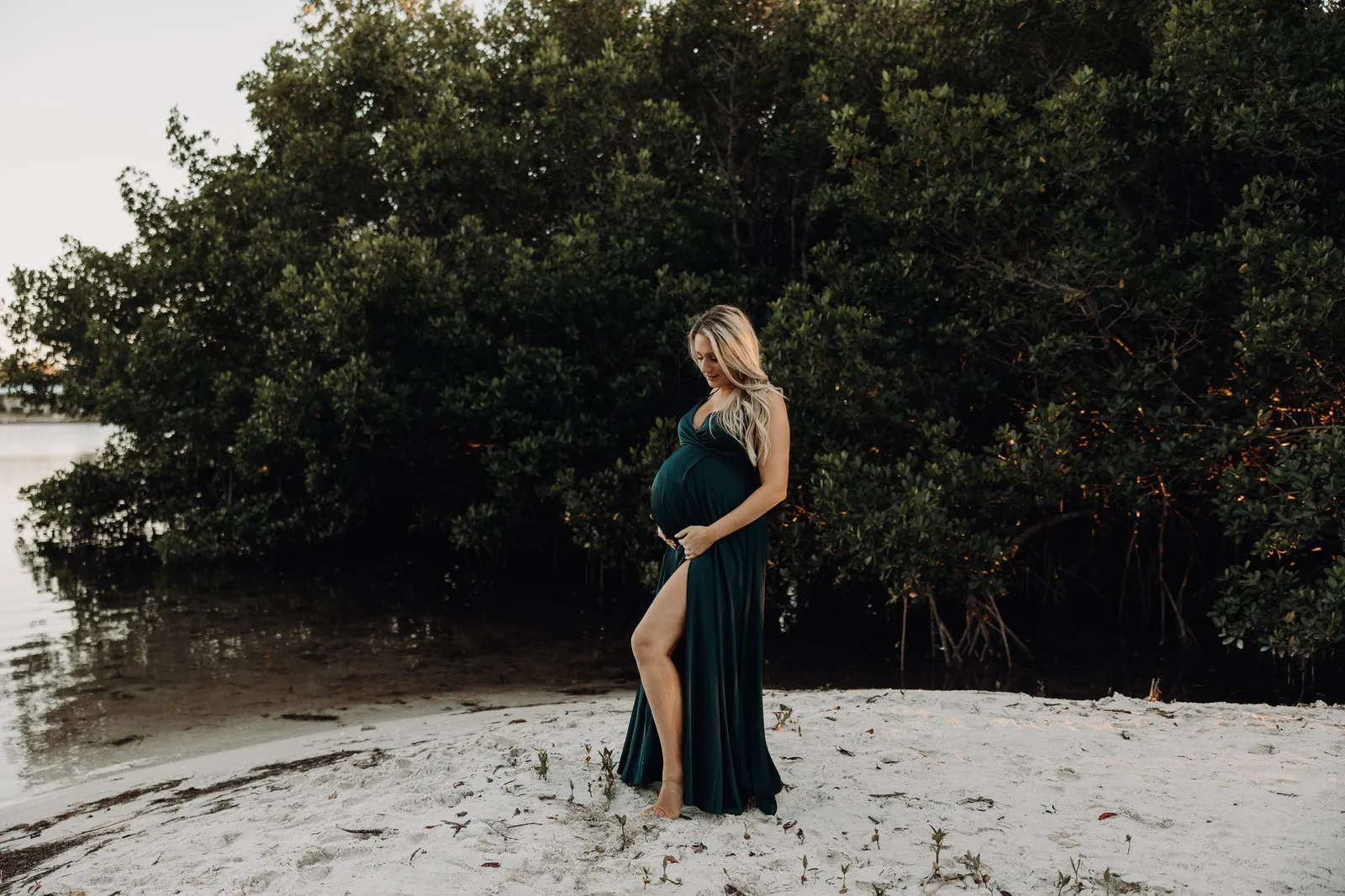 Expectant mother standing on a sandbar in front of mangroves