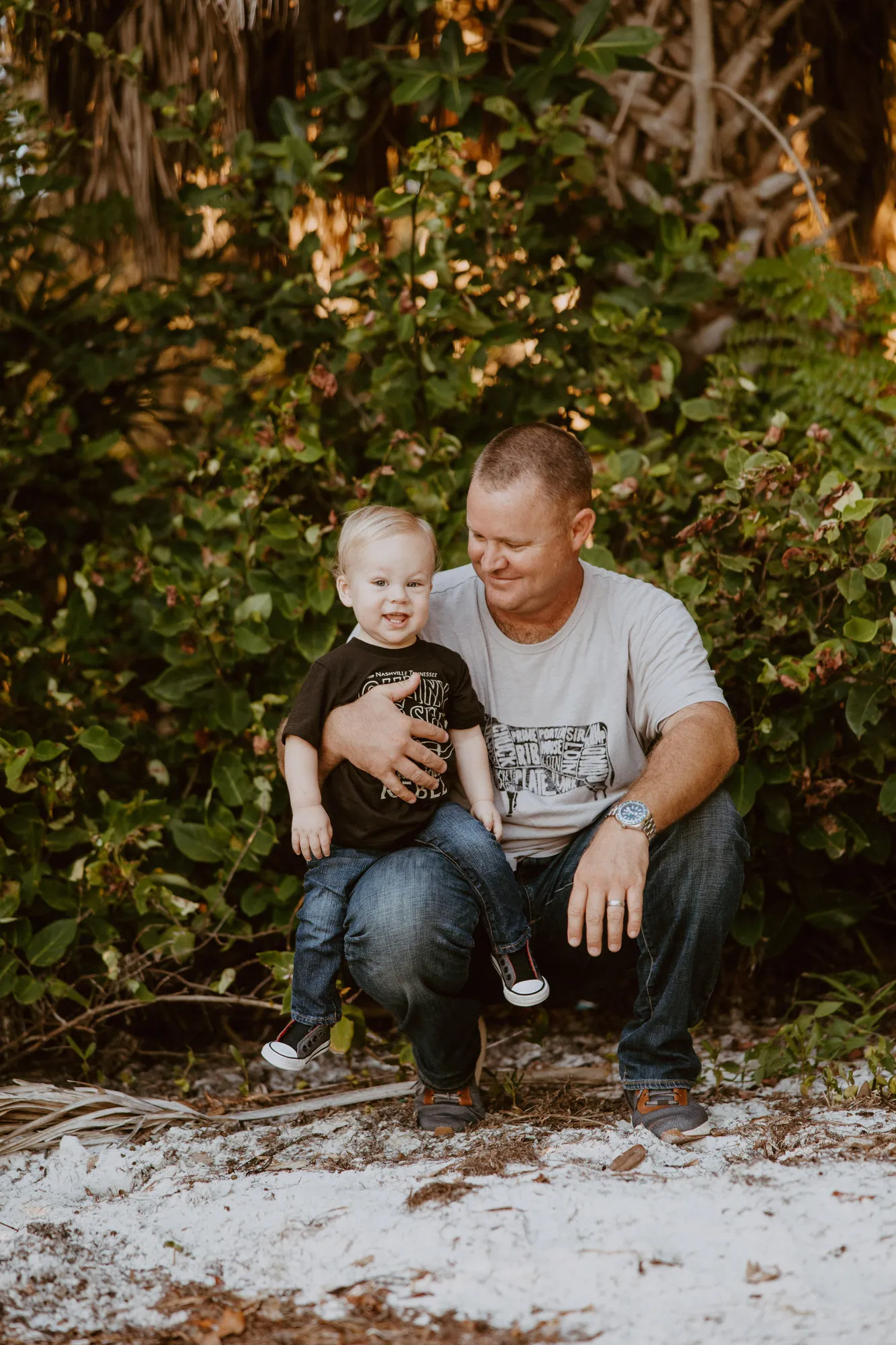 Father kneeling with his son on a sandy path