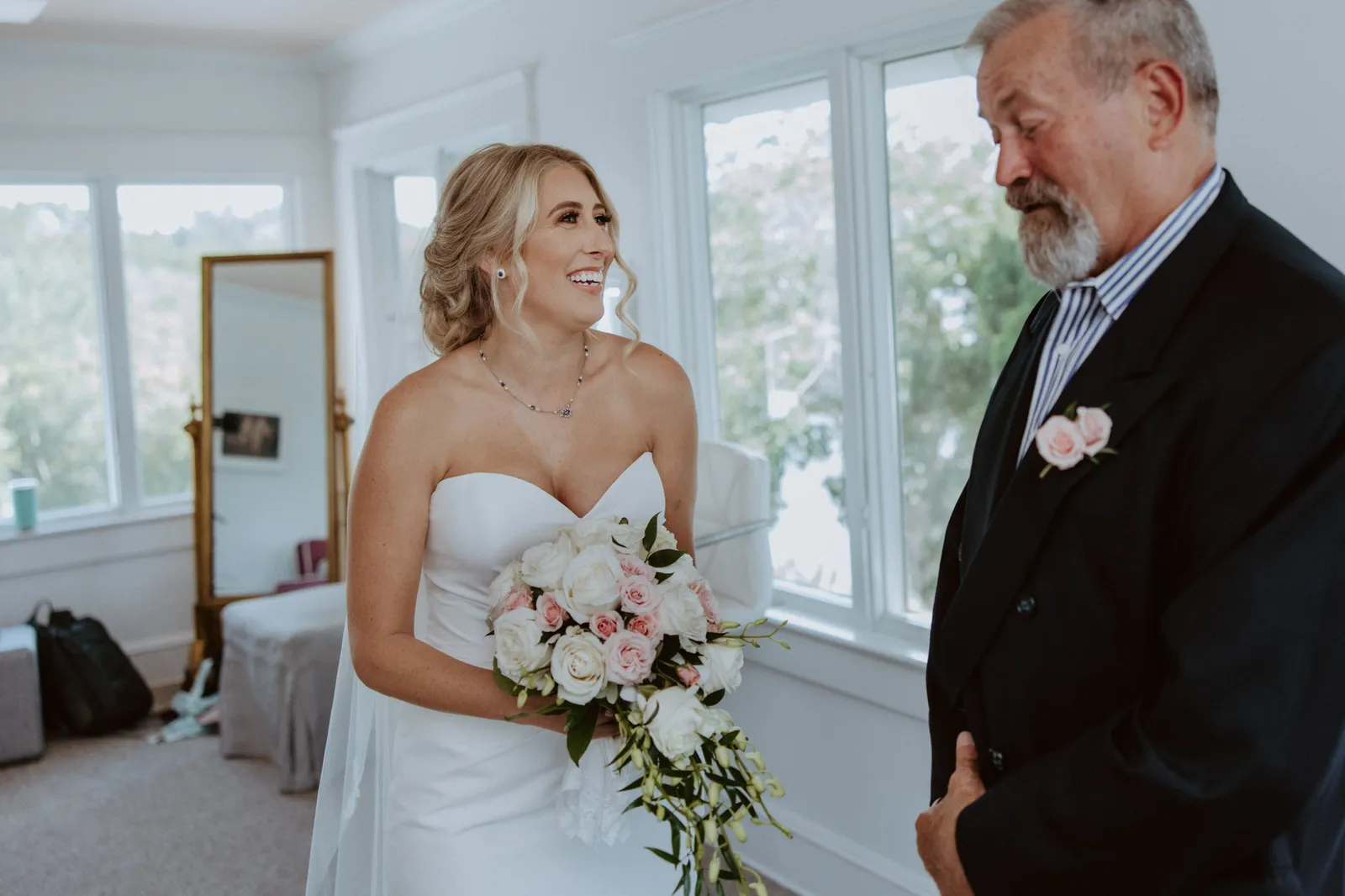 Bride laughing with her father during their first look
