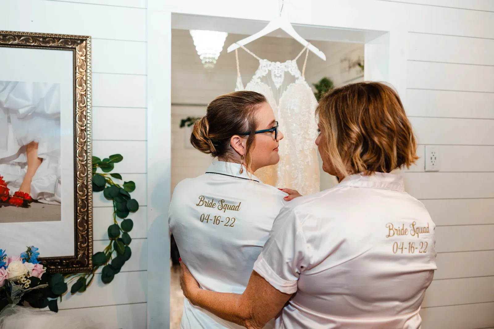 Bride and a woman with their arms round each other, their shirts embroidered Bride Squad