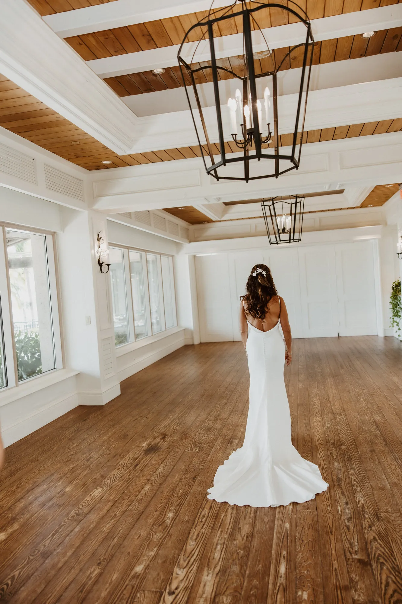 Bride standing alone in her gown, seen from behind