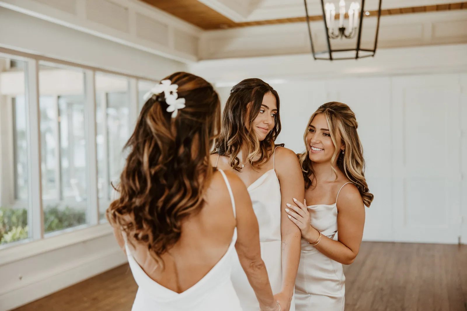 Bride looking back over her shoulder at her two bridesmaids