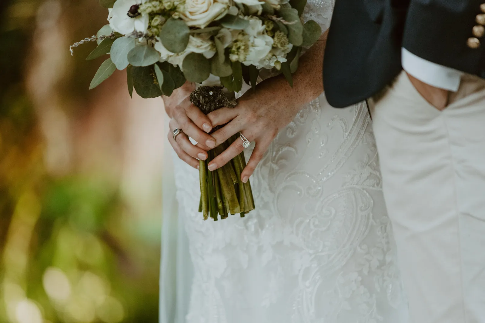 Bride holding her bouquet at her side next to the groom