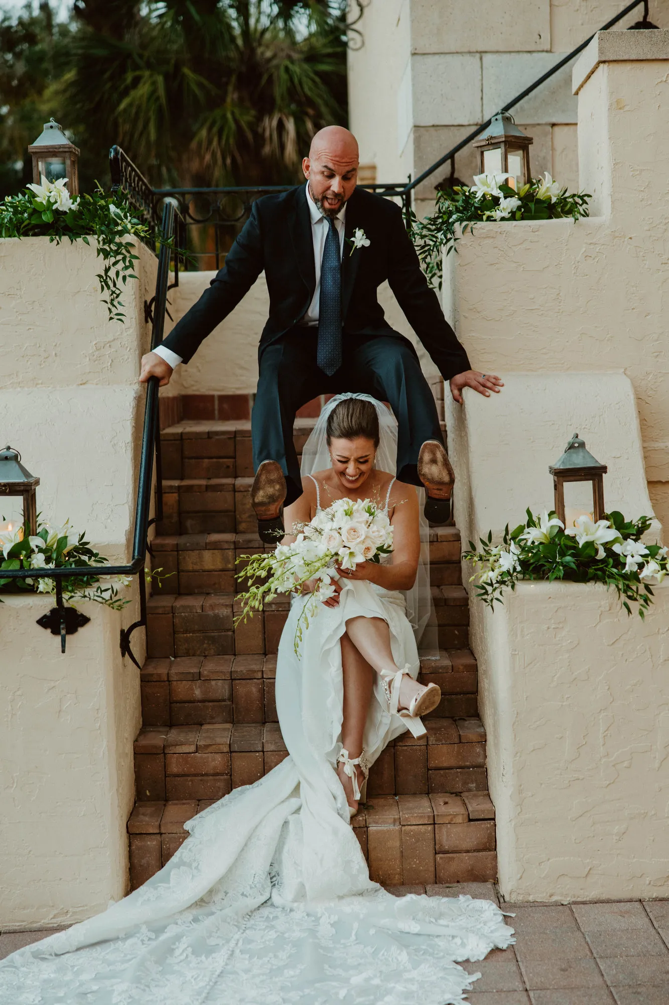 Groom swinging himself up on the stair walls behind his seated bride