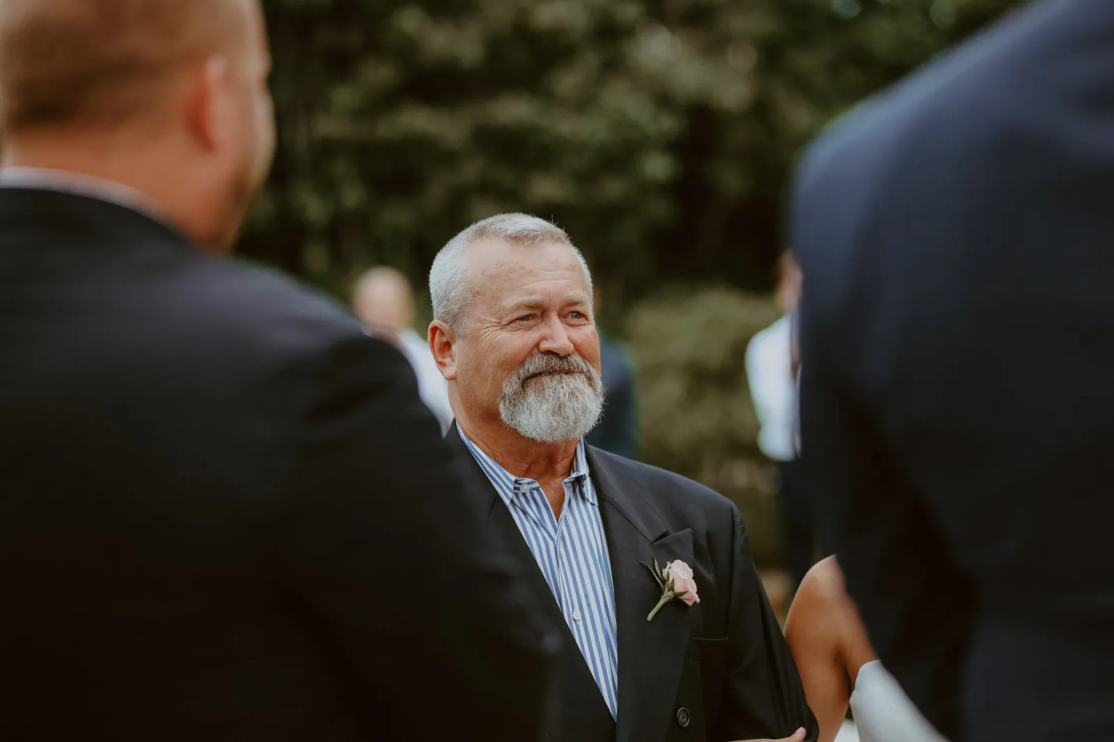Bearded man in a dark jacket smiling at the ceremony
