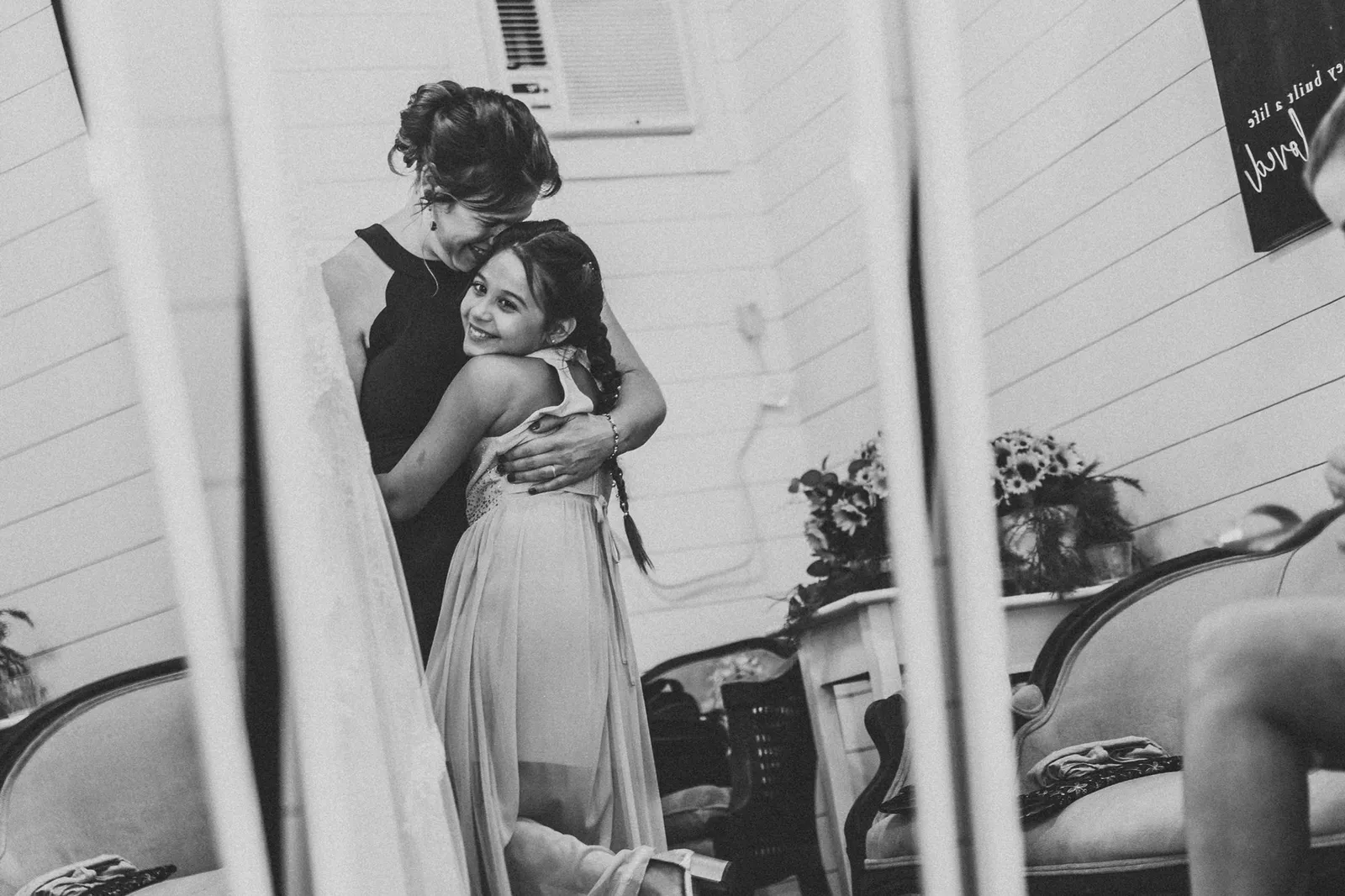 Girl hugging a woman, reflected in a mirror, in black and white