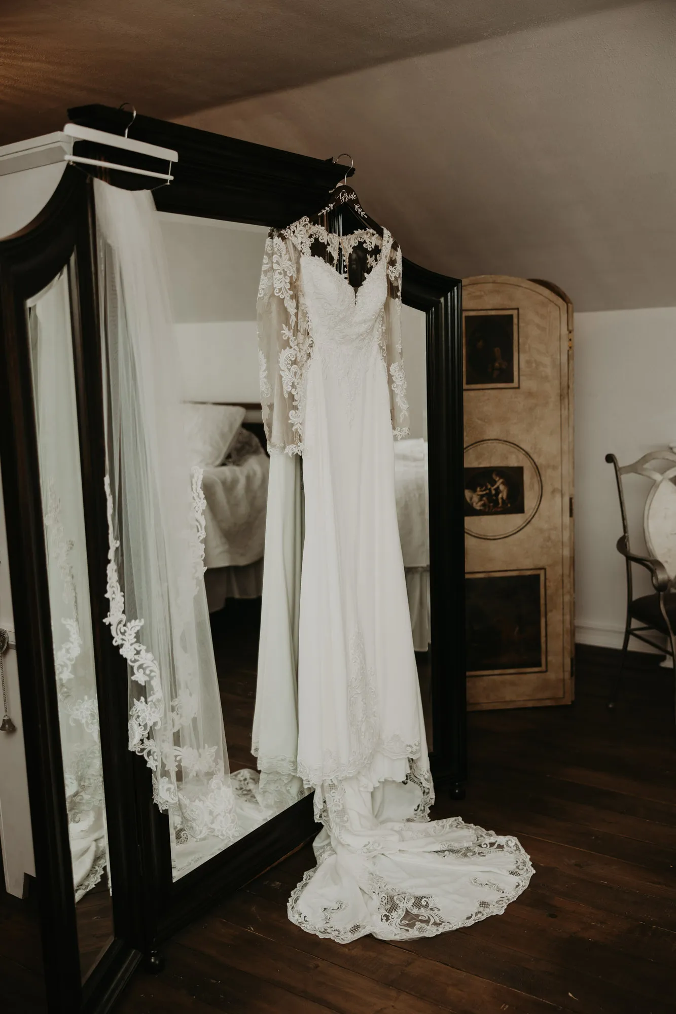 Lace wedding dress hanging on a mirrored wardrobe