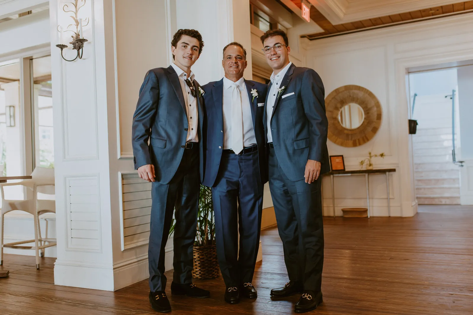 Groom with two groomsmen in blue suits