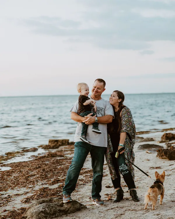 Family of three with their dog on the shore at Emerson Point Preserve