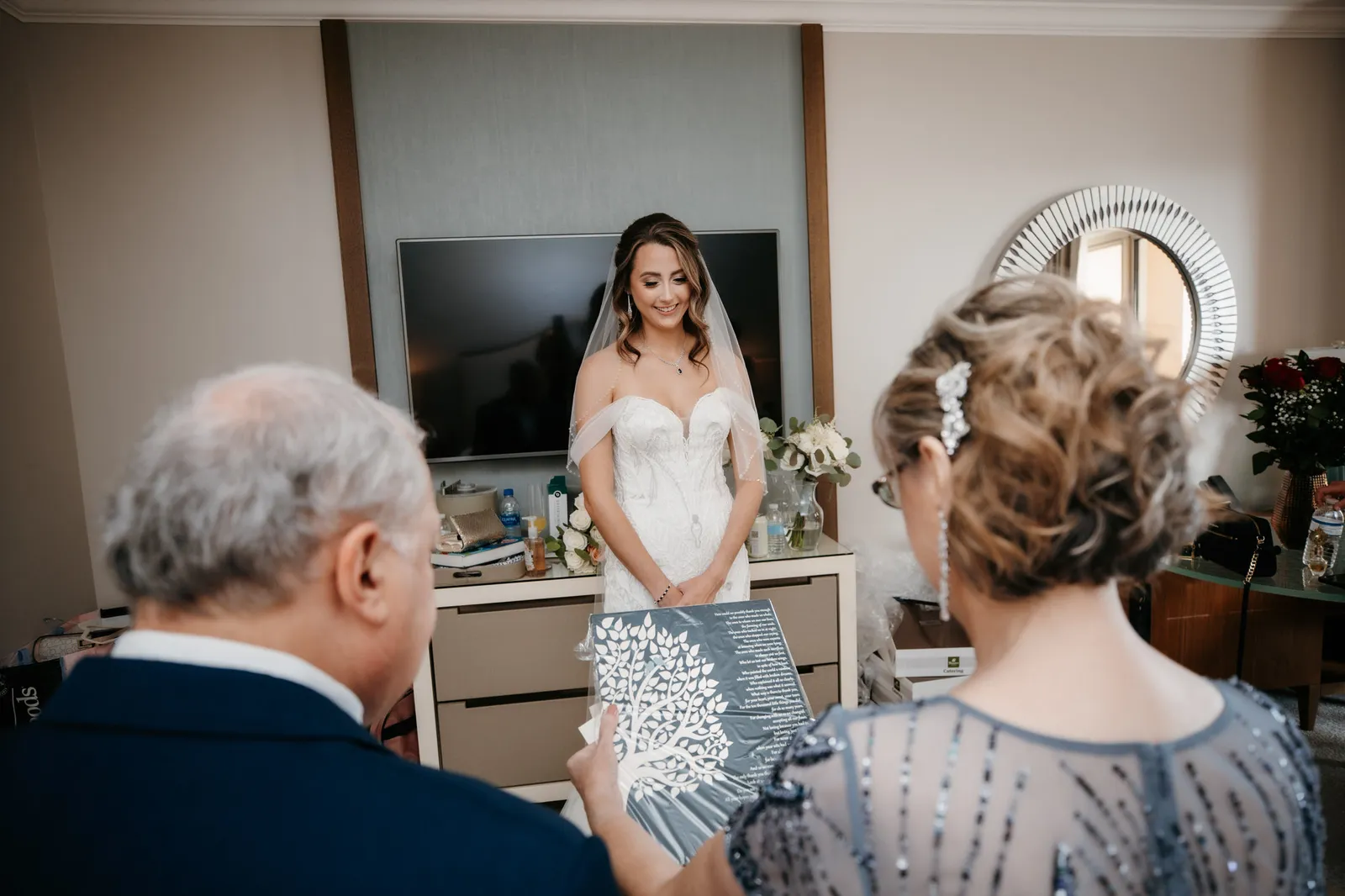 Bride in her dress facing a man and woman as they see her for the first time