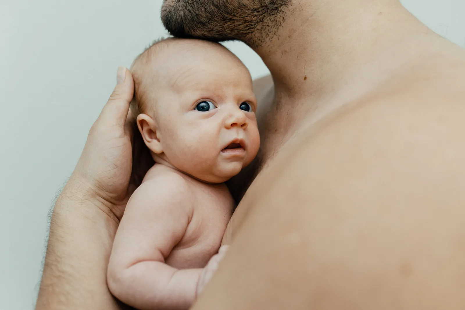 Newborn resting against his father's chest