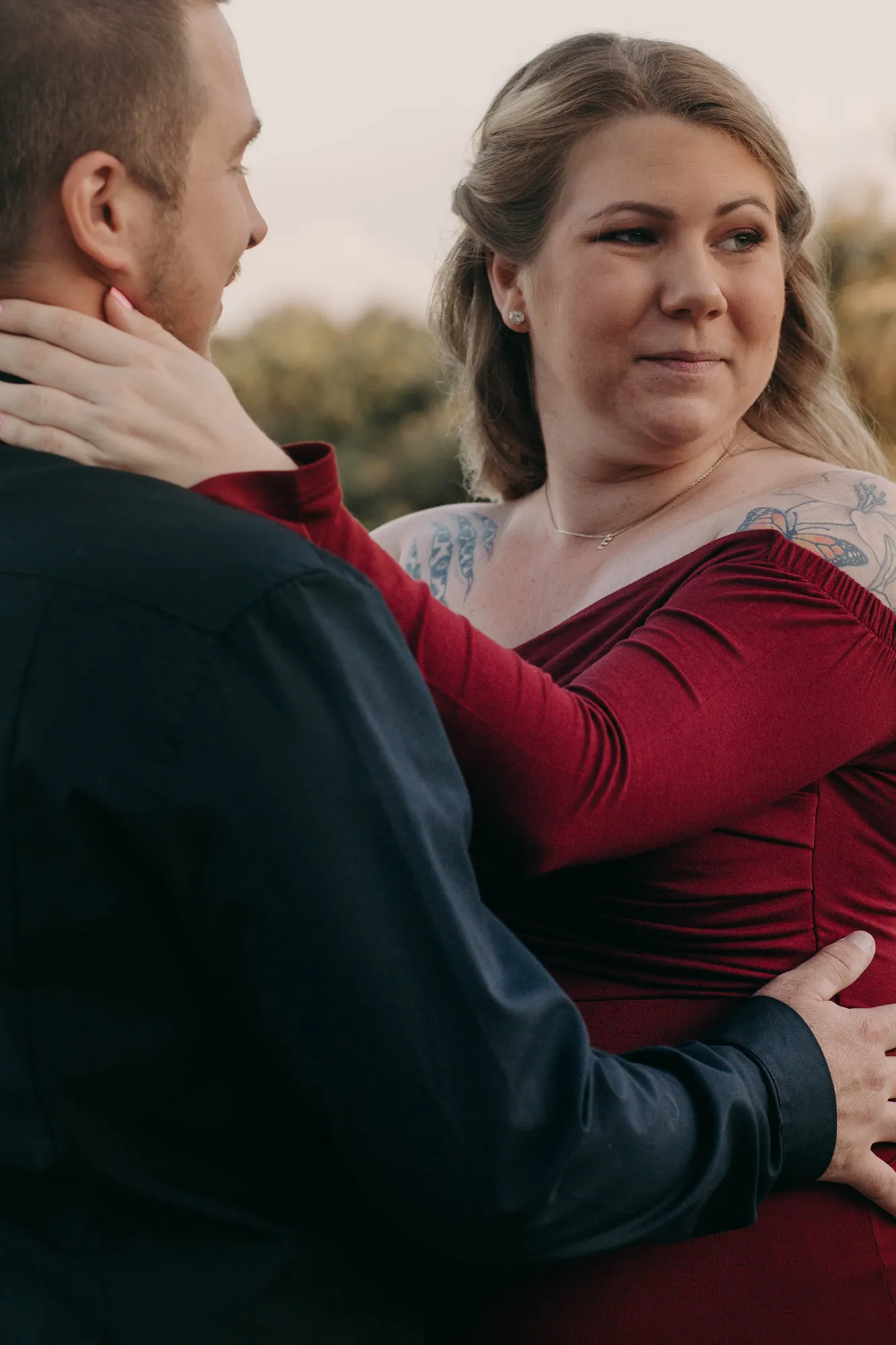 Expectant mother looking up at her partner, his hand on her bump
