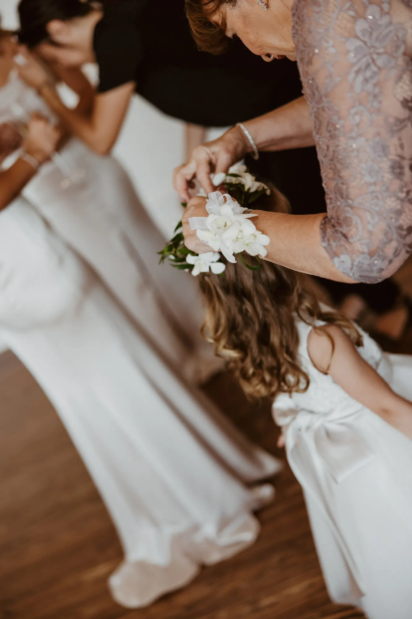 Woman in a lilac dress adjusting the flower girl's floral crown