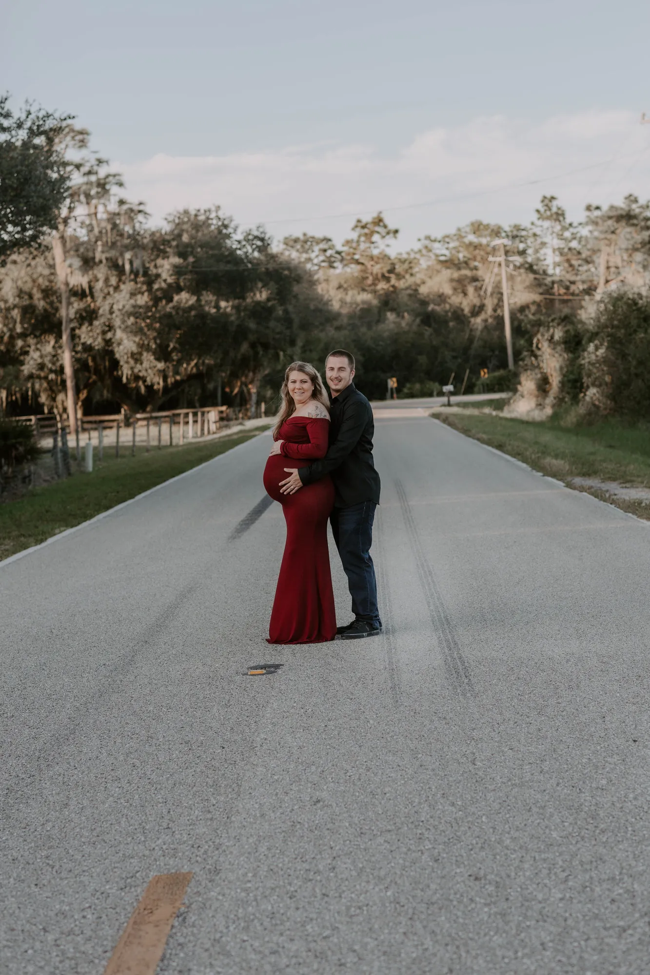 Couple standing on the centre line of a country road, seen from a distance
