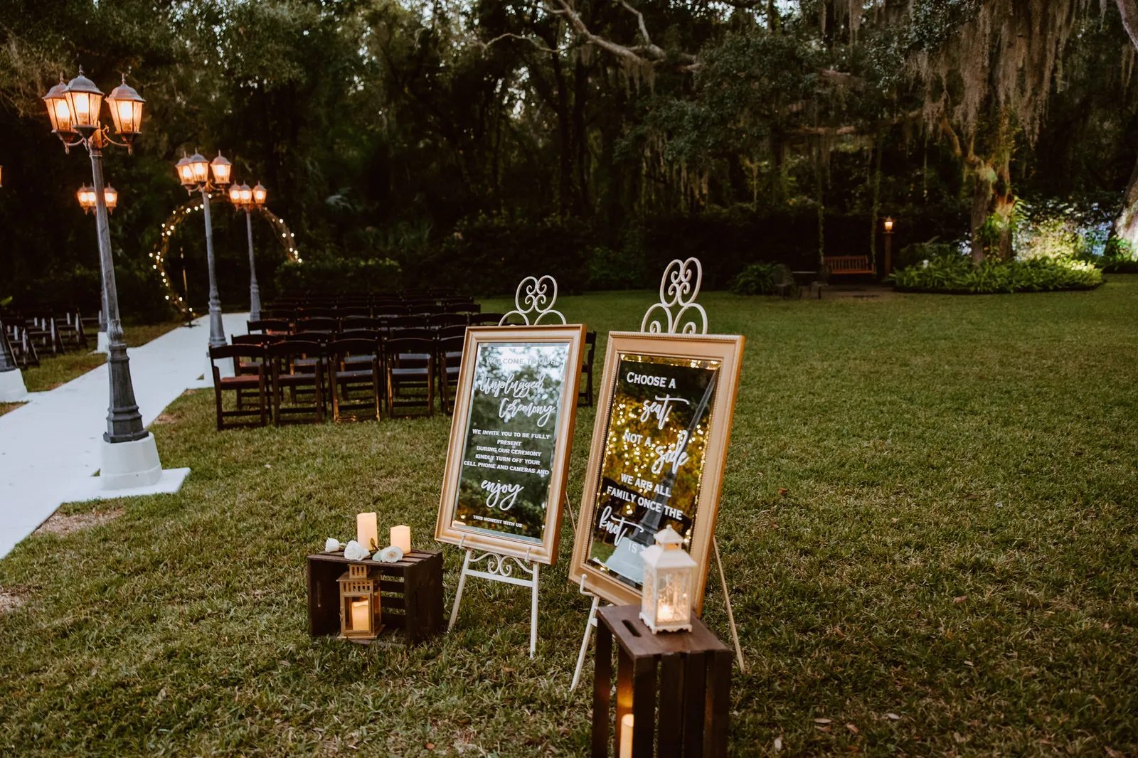 Welcome signs on easels beside the ceremony lawn at dusk