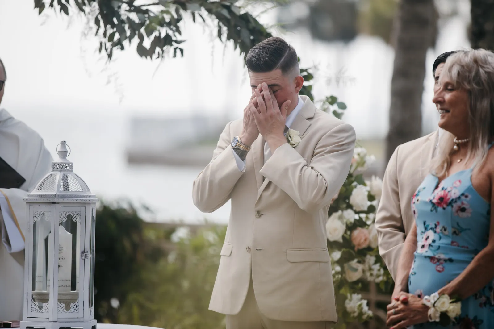 Groom wiping away tears during the ceremony