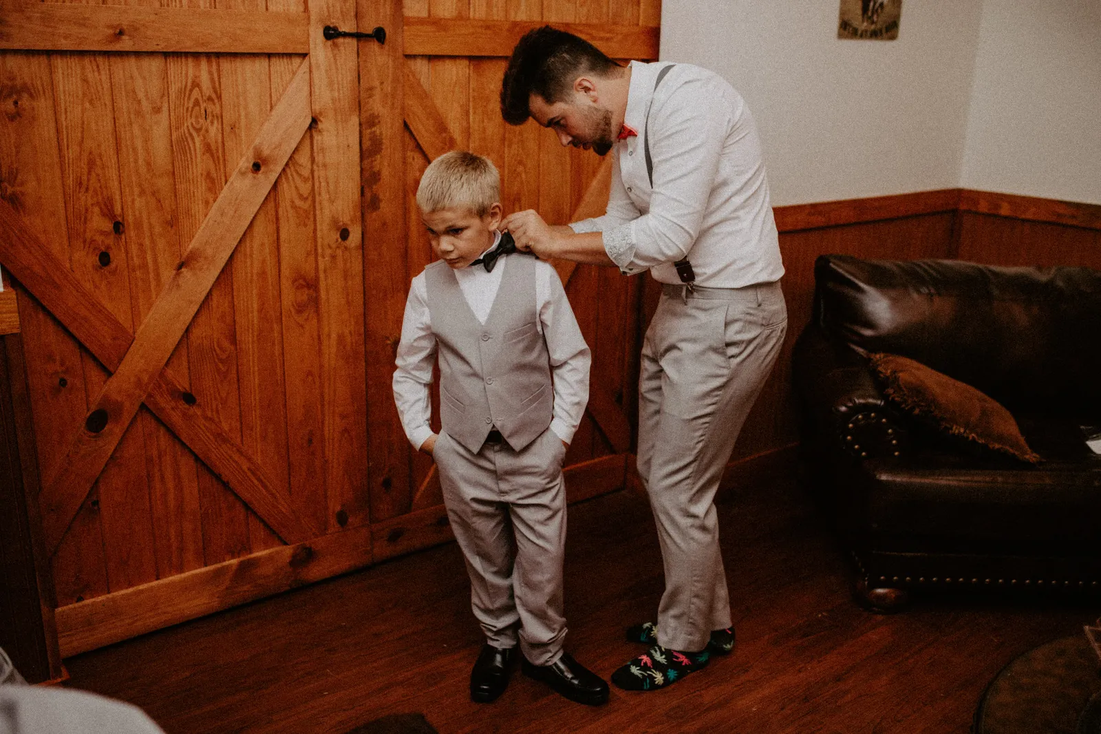 Groom adjusting the ring bearer's bow tie