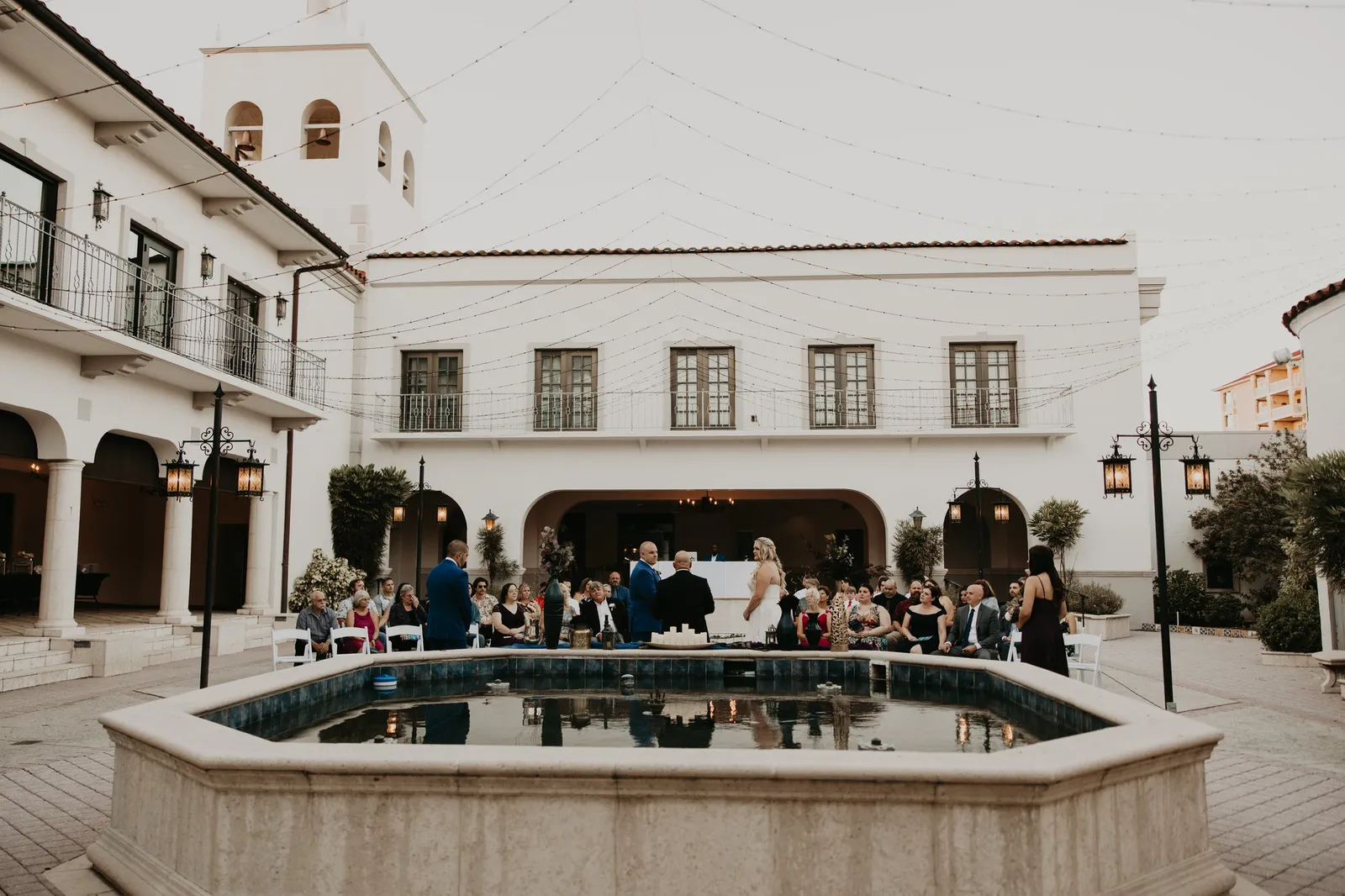 Guests seated around the courtyard fountain at the Bishop Museum