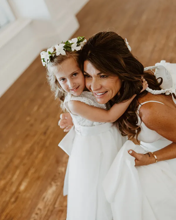 Bride hugging her flower girl at the Ritz-Carlton Beach Club