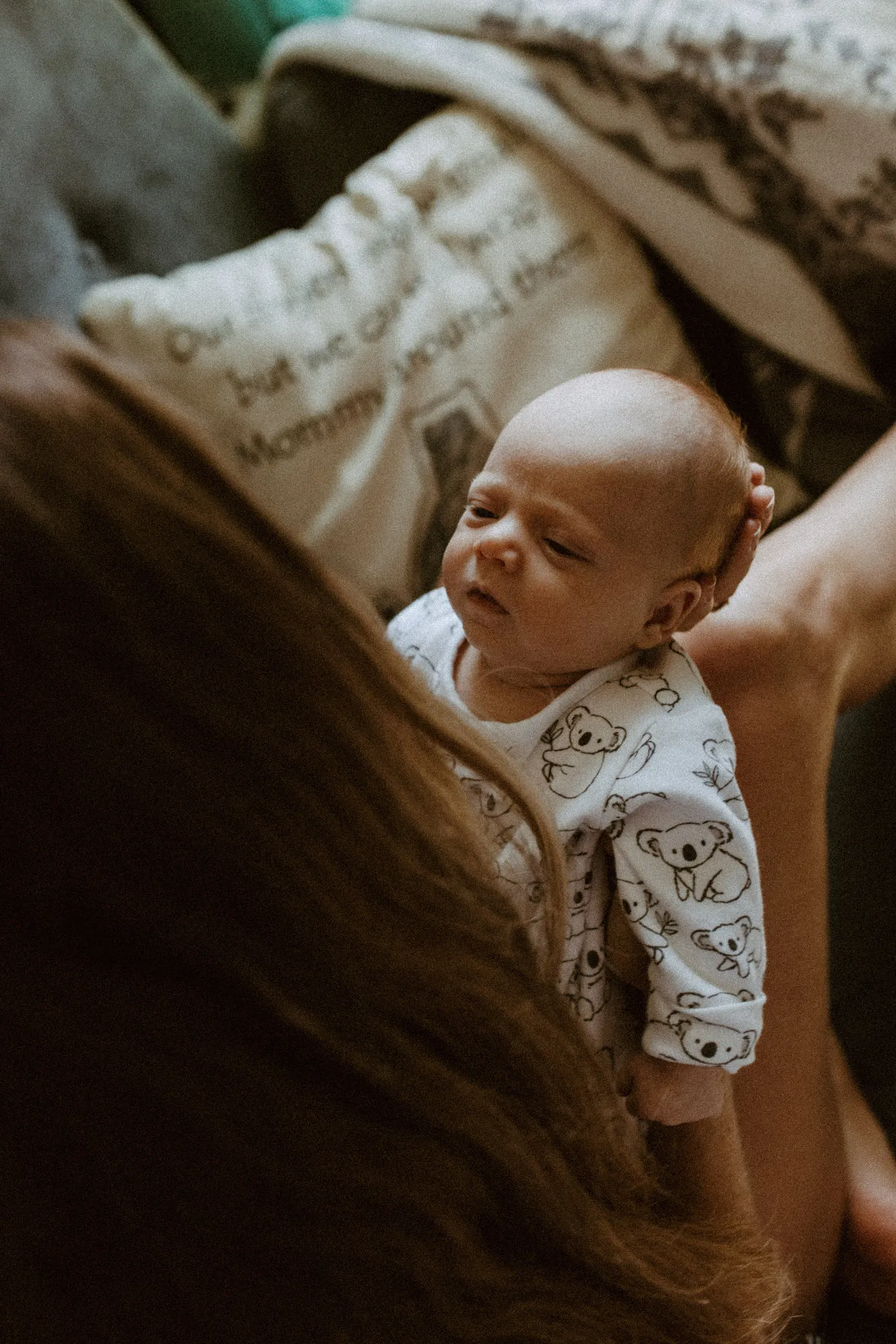 Newborn looking over his mother's shoulder