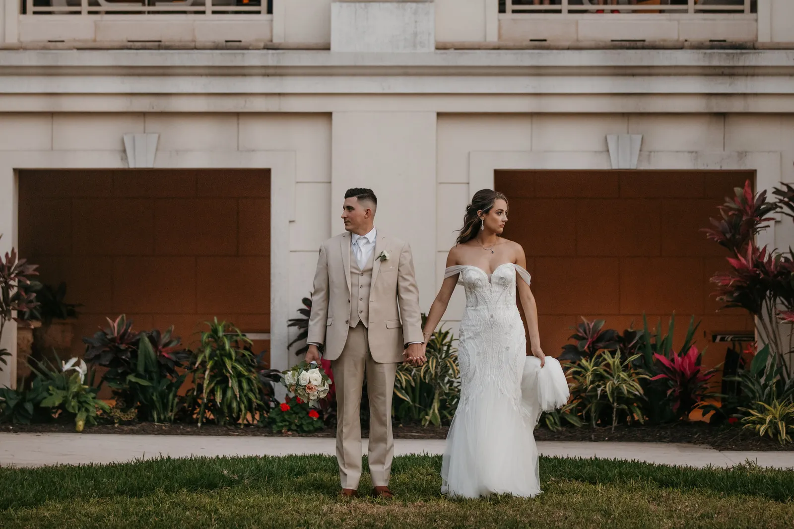 Bride and groom holding hands on the lawn outside the Ritz-Carlton, Sarasota