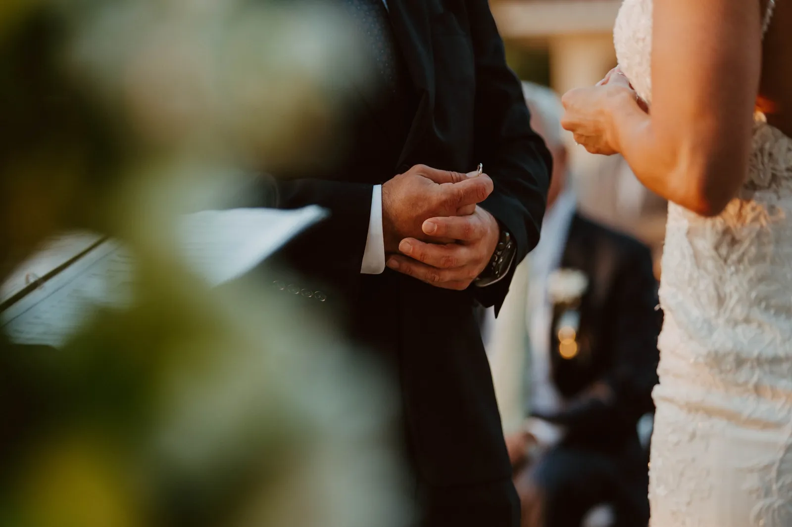 Close-up of the groom's clasped hands during the ceremony
