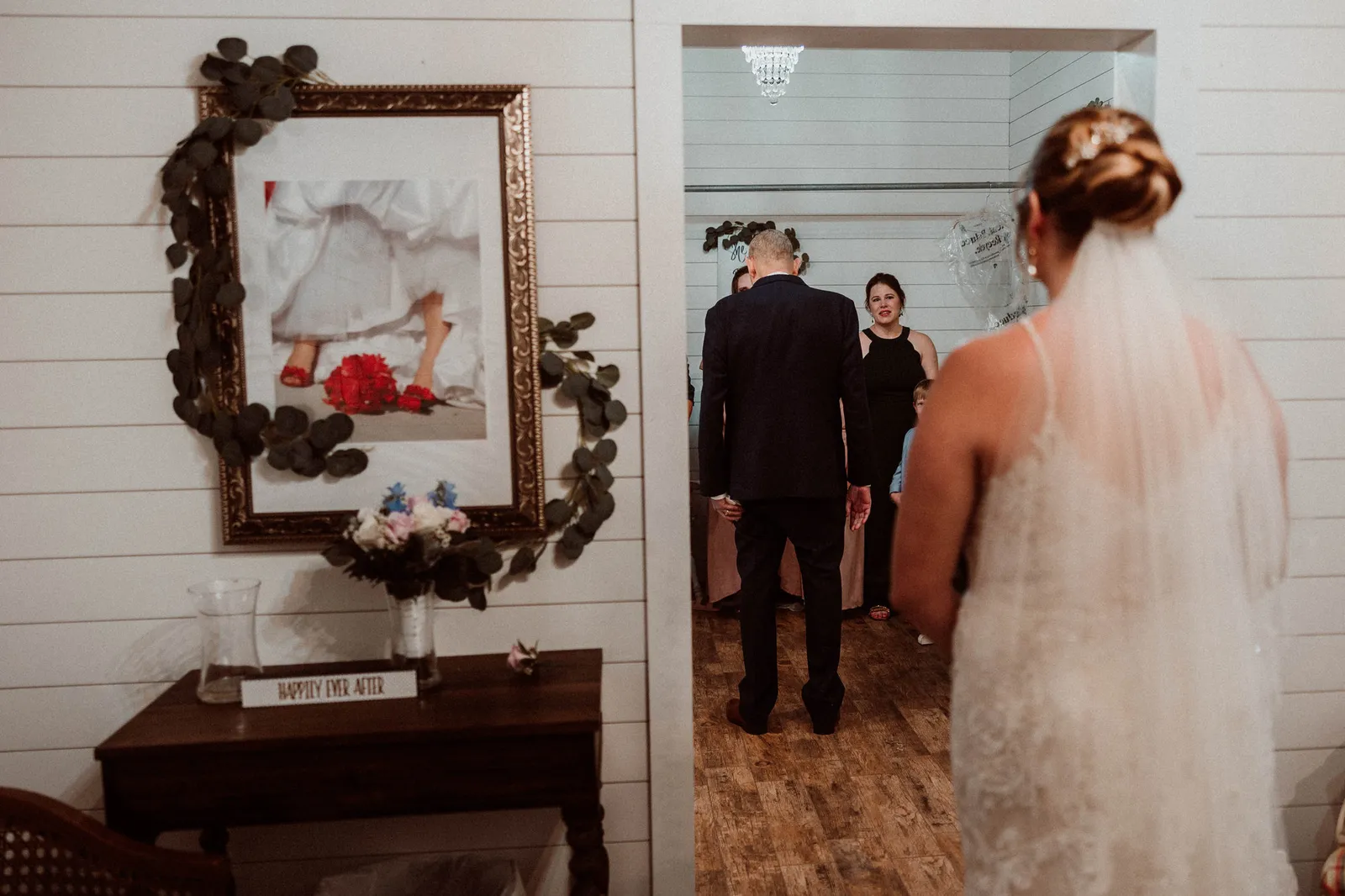Bride waiting behind a man in a suit before he turns to see her
