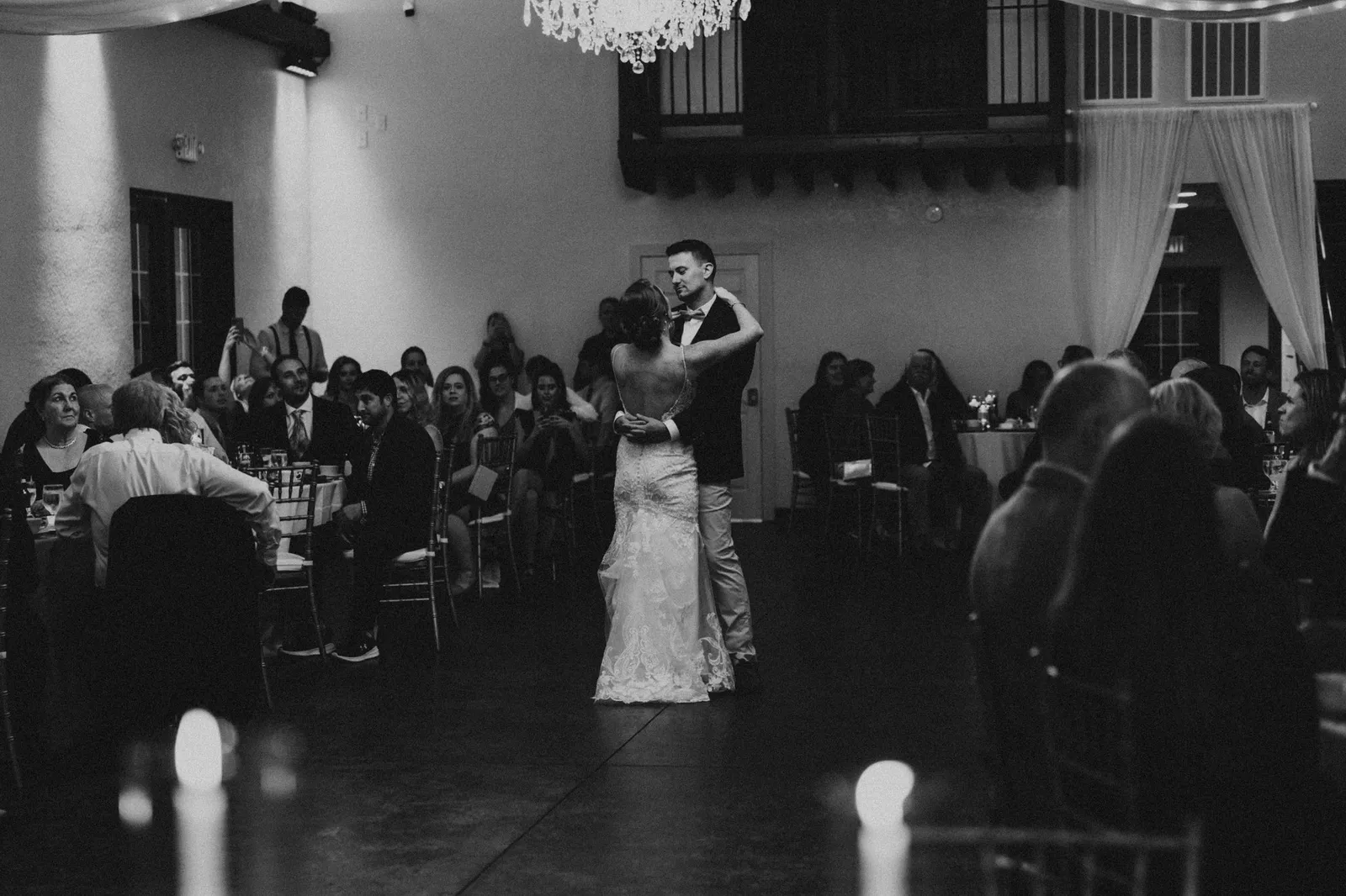 First dance seen from the back of the reception hall, in black and white