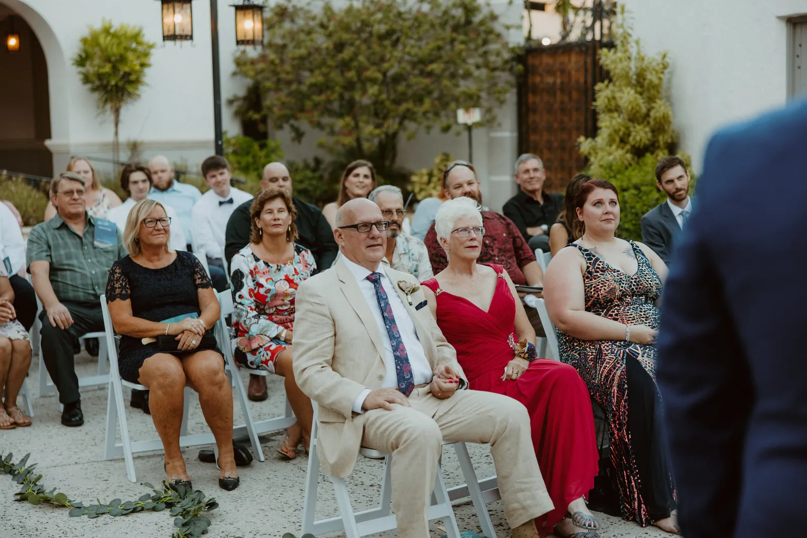 Guests watching the ceremony in front of the courtyard arches