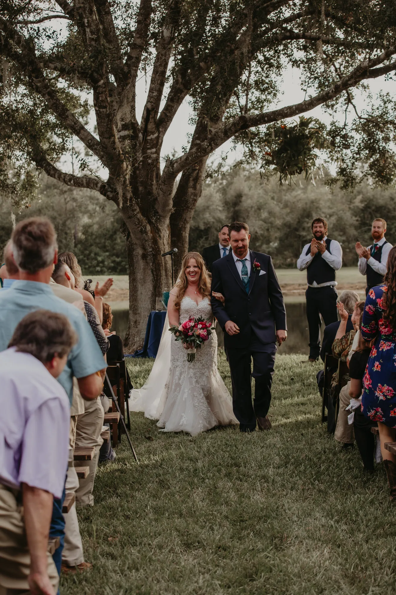 Newlyweds walking back up the aisle past their guests