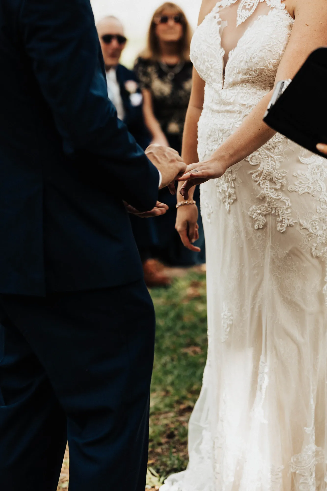 Groom sliding a ring onto the bride's finger