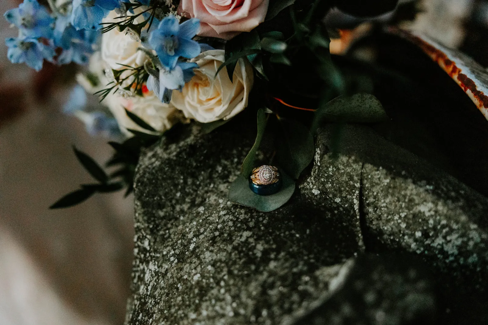 Wedding rings on the tractor tyre beneath the bouquet