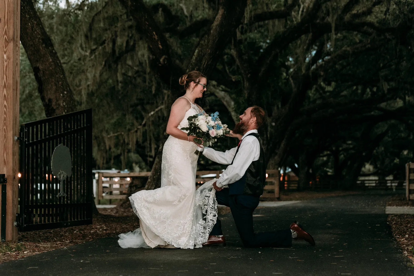 Groom kneeling before his bride by the gate