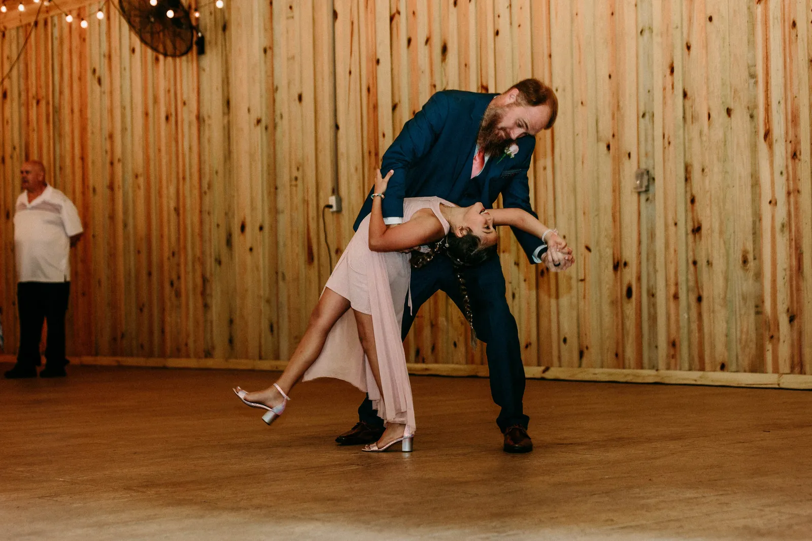 Groom dipping the girl in pink during their dance