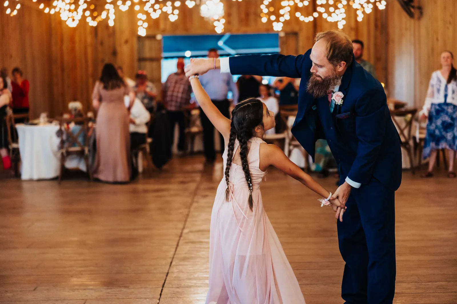 Groom twirling the girl in pink on the dance floor
